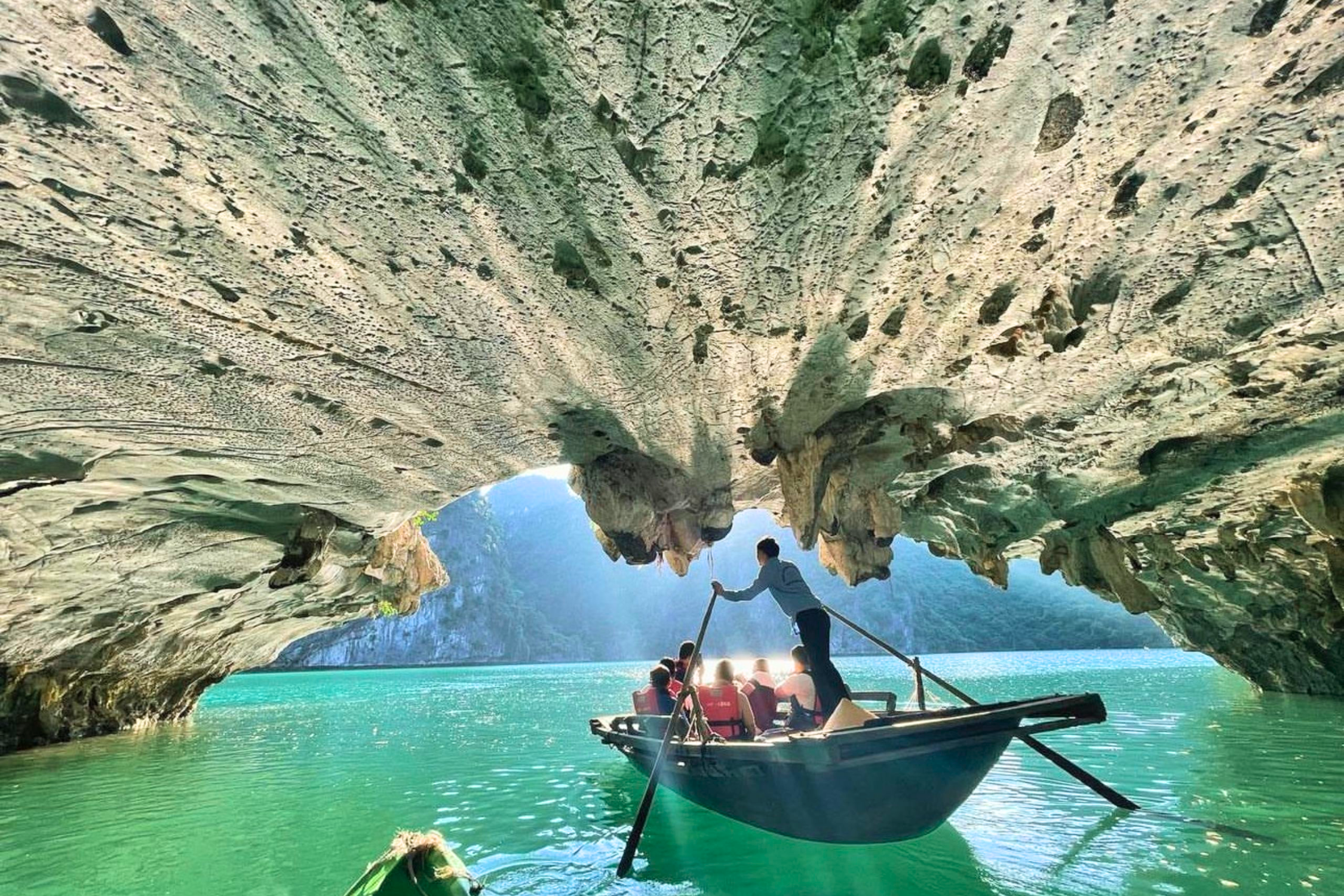 Tourists take a bamboo boat ride through the Dark & Bright Cave